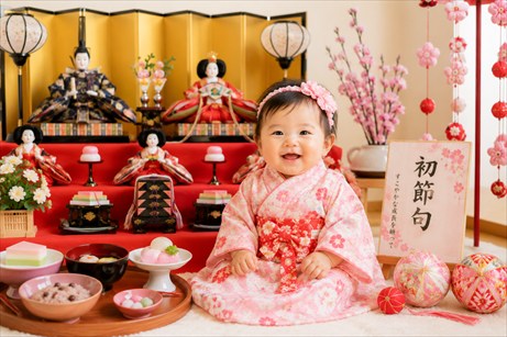赤ちゃんがひな人形の前で記念写真
